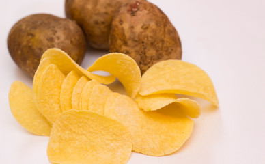 Potato chips with fresh potatoes on a white background
