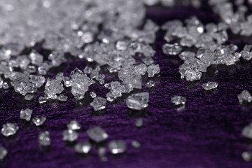 White sugar crystals on a dark violet background