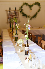 Wedding. Banquet. The chairs and round table for guests, served with cutlery, flowers and crockery and covered with a tablecloth.