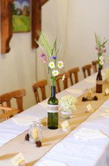 Wedding. Banquet. The chairs and round table for guests, served with cutlery, flowers and crockery and covered with a tablecloth.