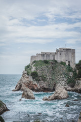 Fototapeta na wymiar Blick auf Festung von Dubrovnik am Meer Felsen und blauer Himmel
