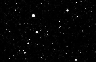 falling snow at night. snowfall at night. white chaotic spots on a black background