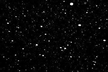 Obraz premium padający śnieg na czarnym tle, opady śniegu w nocy, białe chaotyczne plamy na czarnym tle