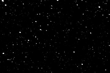 falling snow on a black background, snowfall at night, white chaotic spots on a black background