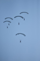 army soldiers jump with parachute in the sky