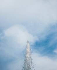 splashes of water against the blue sky with clouds