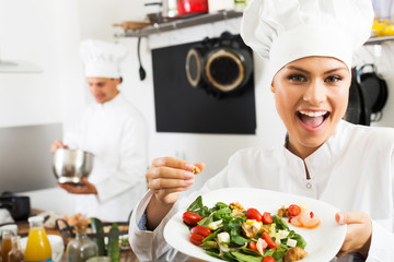 Woman chef serving fresh salad