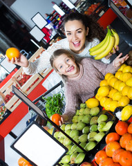 Fototapeta na wymiar Woman and daughter purchasing fruits