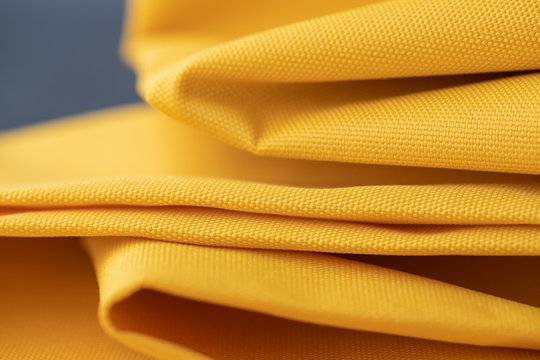 Close-up waterproof and water repellent fabric. Folded canvas of yellow textile