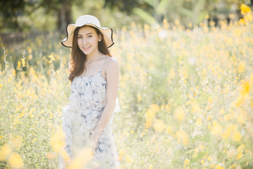 Fototapeta na wymiar happy young woman enjoying summer in yellow flower field