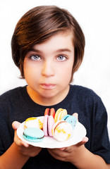 Handsome boy eating macaroni over white background.