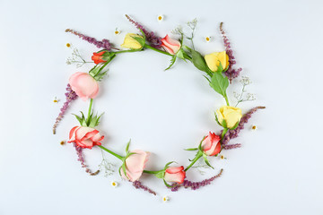 Feminine frame background made of various flowers with a lot of copy space for text. Close up, top view, flat lay.