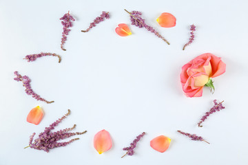 Feminine frame background made of various flowers with a lot of copy space for text. Close up, top view, flat lay.