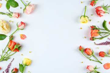 Feminine frame background made of various flowers with a lot of copy space for text. Close up, top view, flat lay.