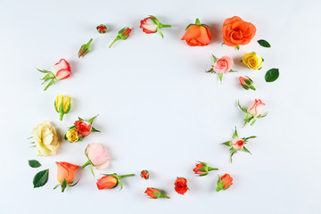 Feminine frame background made of various flowers with a lot of copy space for text. Close up, top view, flat lay.