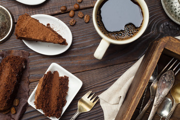 Slices of truffle chocolate cake and coffee on the wooden table