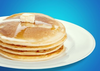 Stack of tasty pancakes with butter on a white plate
