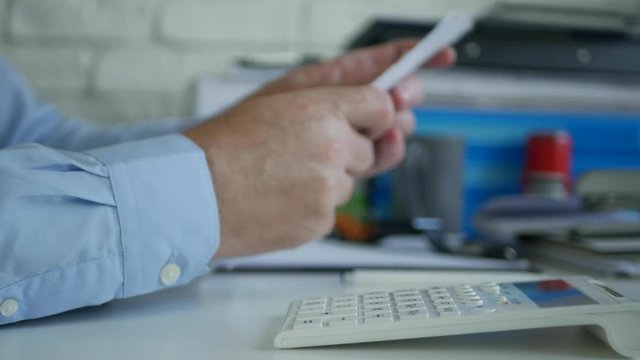 Businessman in Accounting Office Calculate Bills Using Adding Machine