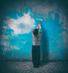 Improve your perspective. Child paints a sky on a gray wall
