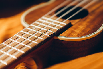 Fototapeta premium Ukulele closeup. Orange and dark background.
