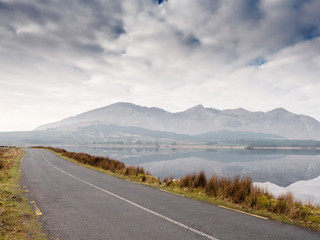 Empty road by a lake, mountains in the background, Connemara national park, county Galway, Ireland.