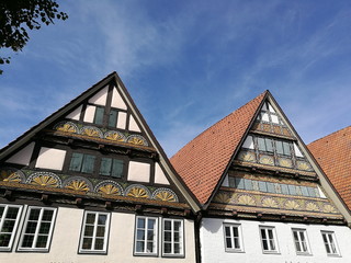 Liebevoll restaurierte alte Fachwerkhäuser mit Spitzgiebel bei blauem Himmel und Sonnenschein in...