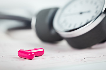 Medical pills on the background of ECG, cardiogram and cardiac gauge.  Diagonics, prevention and...