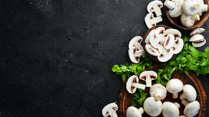 Mushrooms sliced on a black table surface. Top view. Free space for text.