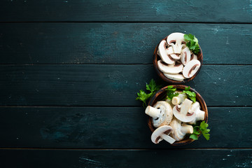 Mushrooms sliced on a black table surface. Top view. Free space for text.