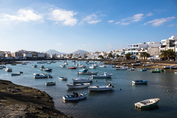 Fototapeta na wymiar Laghetto pieno di barche crea un'atmosfera da villaggio di pescatori - Lanzarote, Isole Canarie