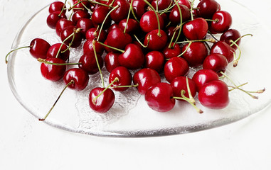 Fototapeta na wymiar Red cherries ripe and sweet on a glass plate ready to eat