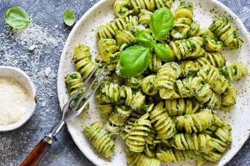 Pasta with pesto and parmesan on a concrete background. View from above.