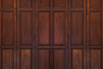 Dark brown old ancient wooden swing door background. Thailand traditional style. Using as wall or wallpaper.