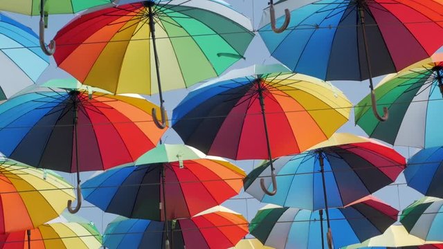 outdoors decoration with many colorful umbrellas against blue sky and sun