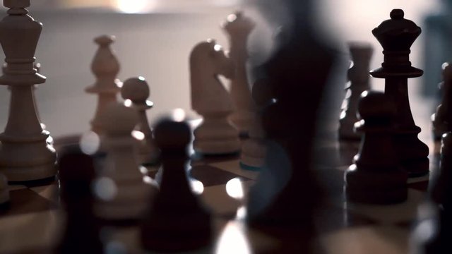 Chess board with wooden pieces. White knight. Close-up. Circular movement of the camera, dolly shot.