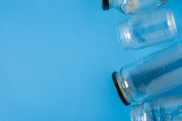 Isolated glass jars laid flat on blue background with room for copyspace on left