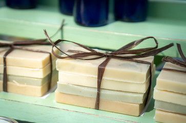 This photo shows bars of handmade or homemade soaps that are tied up in gift packages of 4.