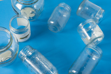 Isolated glass jars without lids flat on blue background with room for copyspace