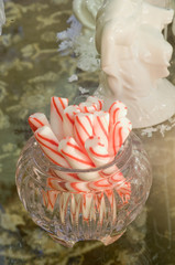 Candy canes in a glass bowl at a holiday party.