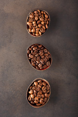 Coffee beans of different varieties and different roasts in three wooden bowls