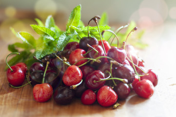 ciliegie sul tavolo di legno con i rametti di menta