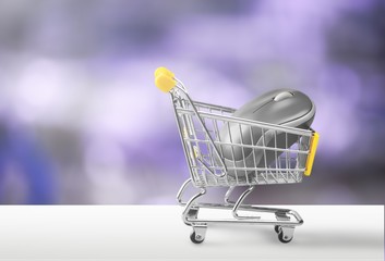 Metallic color computer mouse placed in a miniature-shopping cart.