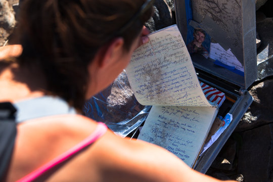 A woman looks at a summit registry on Hyalite Peak in Hyalite Canyon, Montana.