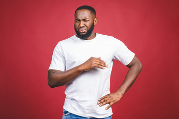 Closeup portrait of dumb clueless young african man, arms out asking why what's the problem, I don't know. Isolated on red background. Negative human emotion facial expression feelings