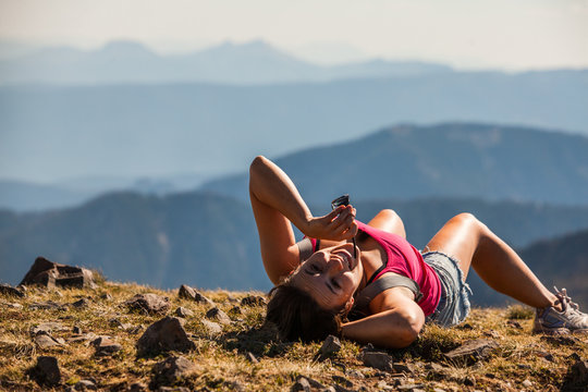 A woman soaks up the sun while resting after day hiking to the top of Hyalite Peak in Montana.