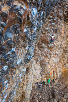 A woman climbing the pumpy 90-foot Pit Lizard (5.11a) in the PIt at Deep Creek, a climbing area near Spokane, Washington.