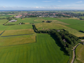 Fototapeta na wymiar Aerial of meadowland with curving road and farms on the dutch island of Texel