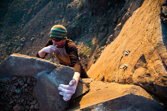 A man clips the anchors after finishing Burning Spears. a 5.10c trad route at Vantage.