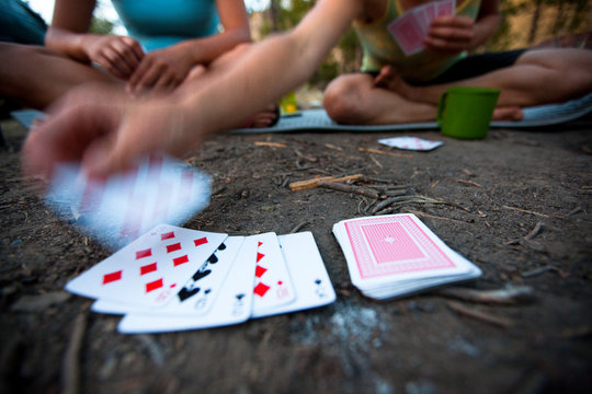 Two women play cards and enjoy a fire while car camping along the Salmon River near Stanley. Idaho.    
