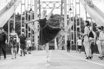Young ballerina in ballet costume dancing in city , feeling breath of big city life and freedom	 